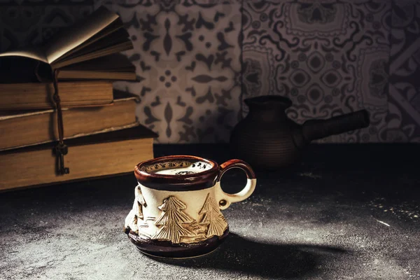 Cup of coffee and books. Steaming coffee cup and traditional turkish coffee pot cezve. Cozy home atmosphere for reading and resting