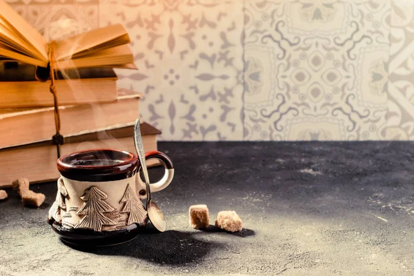 Cup of coffee and books. Steaming coffee cup and traditional turkish coffee pot cezve. Cozy home atmosphere for reading and resting