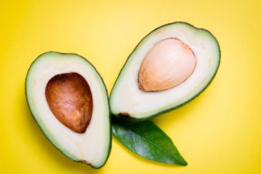 Sarı arka plan üzerinde avokado. Avokado ve yaprak tropikal arka plan. Düz yatıyordu, en iyi görünümü