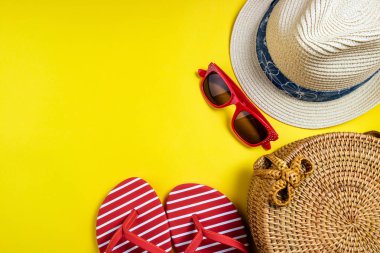 Yaz kadın moda plaj aksesuarları flip flop, hasır şapka, sarı arka plan üzerinde güneş gözlüğü. Yolculuk, meslekler, seyahat ve yaz dinlenme konsepti