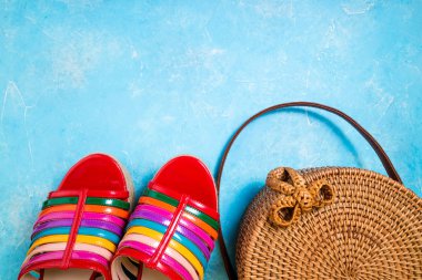 Moda bambu çanta ve mavi arka plan düz parlak kadın sandalet yatıyordu. Kadın yaz aksesuarları. Yaz moda konsepti