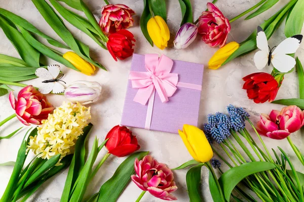 Εορταστική φόντο με λουλούδια και κουτί δώρου. Τουλίπες, ανοιξιάτικα λουλούδια και δώρο. Ευχετήρια κάρτα, γιορτές, Πάσχα, η ιδέα της μητέρας. Επίπεδη ωοτοκίδα — Φωτογραφία Αρχείου