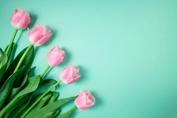 Buquê de flores de tulipas em fundo festivo a cores. Flores de primavera no cartão floral flat lay. Cartão de saudação, conceito feriados — Fotografia de Stock