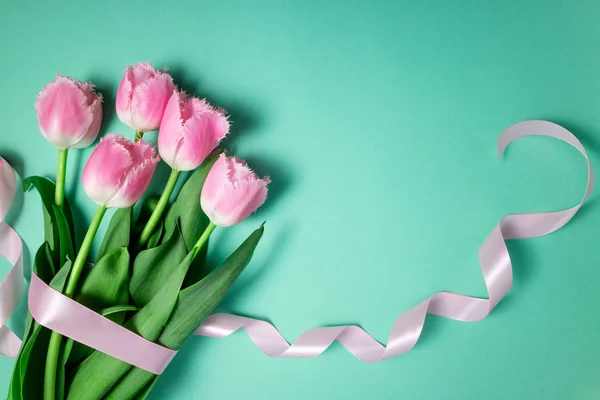 Ramo de flores de tulipanes sobre fondo festivo de color. Flores de primavera en la tarjeta floral plana laico. Tarjeta de felicitación, concepto de vacaciones — Foto de Stock