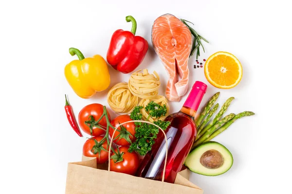 Fondo alimentario saludable. Comida saludable en bolsa de papel pescado, verduras, frutas y vino sobre fondo blanco. Compras concepto de supermercado de alimentos. Comer sano, cocinar la cena — Foto de Stock