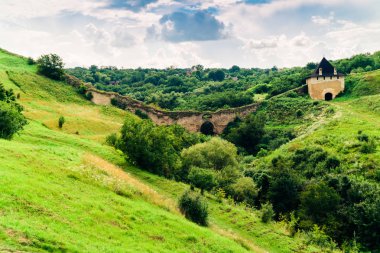 Yeşil tepelerve eski gözetleme kulesi kalıntıları yaz manzarası. Khotyn Kalesi'nin yeri. Yeşil tepeler manzara dramatik sahne. Seyahat konsepti