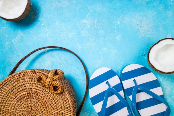 夏季女性时尚海滩配饰拖鞋，竹袋和椰子的蓝色背景。旅程、职业、旅行和夏季休息概念。顶部视图 — 图库照片