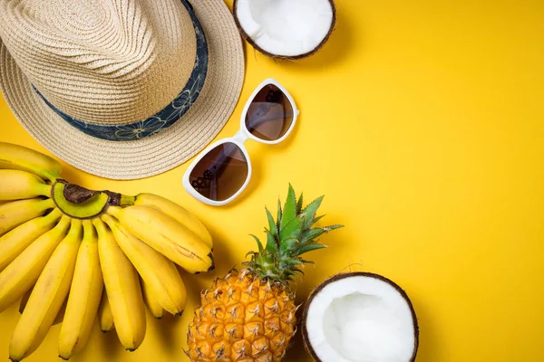 Accesorios de playa de moda femenina de verano sombrero de paja, gafas de sol y frutas tropicales sobre fondo amarillo. Viaje, vocaciones, viajes y descanso de verano — Foto de Stock