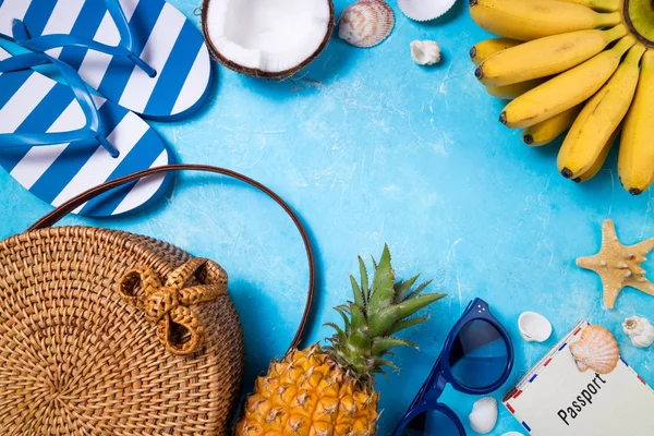 Accesorios de playa de moda femenina de verano chancla, bolsa de bambú, gafas de sol y frutas tropicales sobre fondo azul. Viaje, vocaciones, viajes y descanso de verano — Foto de Stock