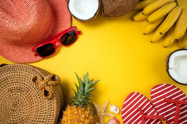 Accesorios de playa de moda femenina de verano chancla, sombrero de paja, gafas de sol y frutas tropicales sobre fondo amarillo. Viaje, vocaciones, viajes y concepto de descanso de verano — Foto de Stock