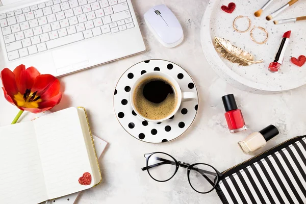 Moda femenina oficina en casa espacio de trabajo plano laico. Espacio de trabajo femenino con portátil, taza de café, tulipán, accesorios y cosméticos, bloc de notas sobre fondo de piedra. Fondo femenino — Foto de Stock