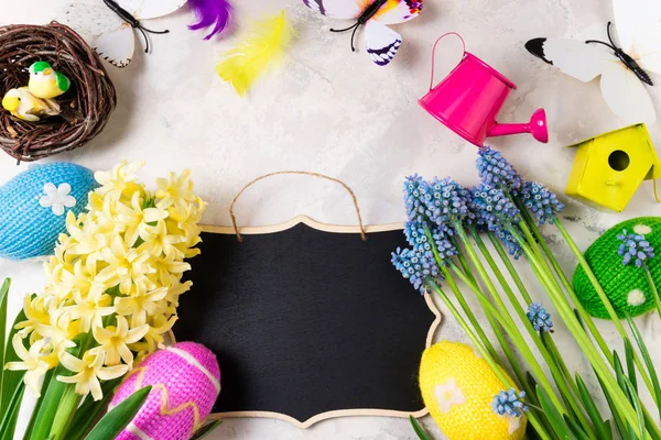 Fondo de Pascua con flores de primavera, huevos de Pascua y decoraciones sobre fondo de piedra. Puesta plana — Foto de Stock