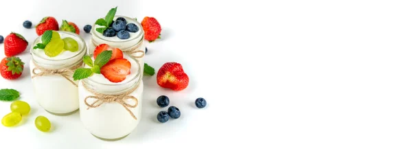 Yogurt fresco con bacche in barattoli di vetro. Prodotti lattiero-caseari. Cibo sano, dieta e concetto di colazione. Formato lungo per banner — Foto Stock