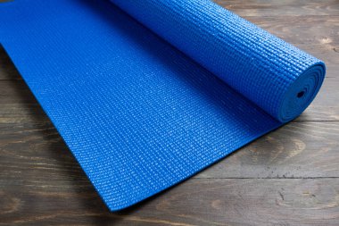 Ahşap arka plan üzerinde Mavi yoga paspas. Yoga için ekipman. Kavram 