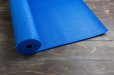 Ahşap arka plan üzerinde Mavi yoga paspas. Yoga için ekipman. Kavram 