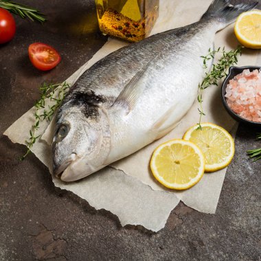 Balık dorado ve pişirme için malzemeler. Çiğ taze deniz balığı ile