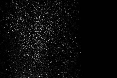 Siyah bir arka plan üzerinde un elenme. Beyaz toz sıçrama izole