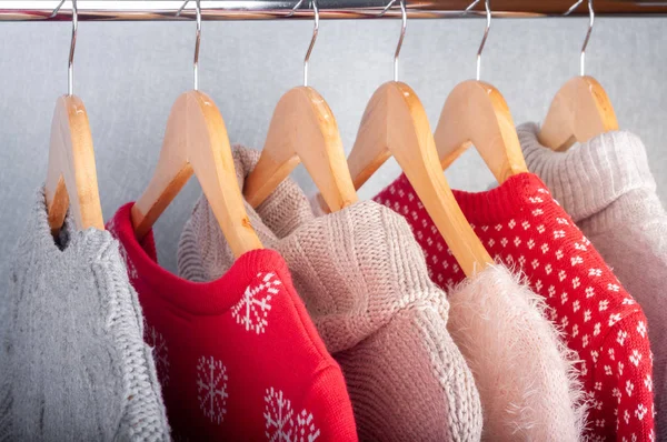 Warm sweaters. Female clothes on open clothes rail. Sale and sho