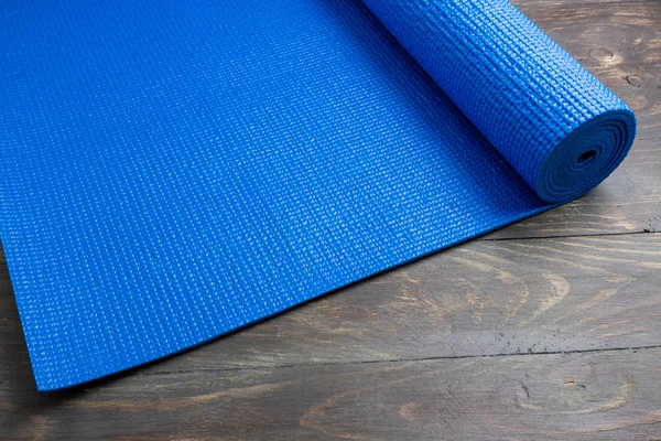 Tapis de yoga bleu sur fond en bois. Équipement pour le yoga. Concept — Photo