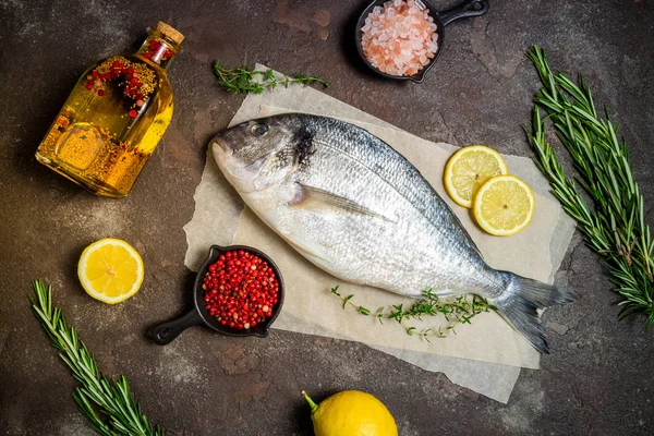 Dorado de peixe cru com fatias de limão, alecrim de ervas, sal e pepp — Fotografia de Stock