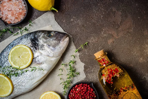 Primer plano del pescado crudo fresco. Dorado pescado con limón, especias y hierbas — Foto de Stock