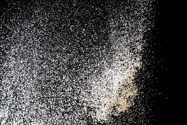 White powder splash isolated on black background. Flour sifting