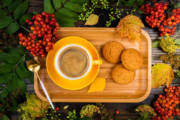 Cozy autumn background with yellow cup of coffee and cookies on