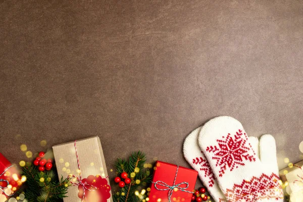 Christmas background with gift box, christmas tree, lights, mitt — Stock Photo, Image