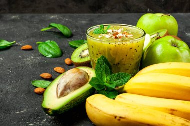 Koyu masada Kivi meyveli smoothie. Muz, avokado ve bademli Kivi yeşili smoothie. Sağlıklı yaz içkisi. Diyet, süper yiyecekler, detoks, sağlıklı yiyecekler, vejetaryen konsepti