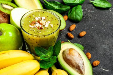 Koyu masada Kivi meyveli smoothie. Muz, avokado ve bademli Kivi yeşili smoothie. Sağlıklı yaz içkisi. Diyet, süper yiyecekler, detoks, sağlıklı yiyecekler, vejetaryen konsepti