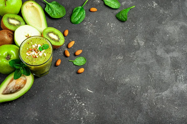 Kiwi fruits smoothie on dark background. Kiwi green smoothie with banana, avocado and almond. Healthy summer drink. Diet, superfoods, detox, healthy food, vegetarian concept. Copy space