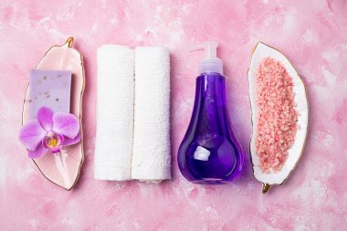 Havlular, spa kozmetik ürünleri, aksesuarlar, sabun, deniz tuzu, masaj fırçası, orkide çiçeği ile kaplıca ya da sağlık konsepti. Vücut bakımı için güzellik ürünleri içeren spa arka planı düz yatıyordu
