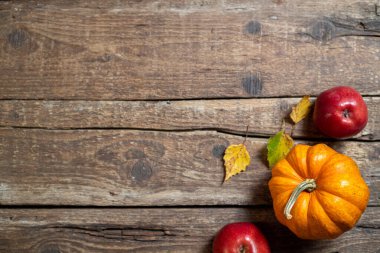 Şükran Günü için sonbahar kompozisyonu. Balkabağı, meyve elması, kırsal ahşap masada sonbahar yaprakları. Sonbahar dekorasyonu. Sonbahar arkaplanı. Üst görünüm, alanı kopyala