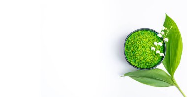 Spa tedavisi sağlık konsepti. Doğal kaplıca ürünleri, banyo için bitkisel deniz tuzu ve beyaz arka planda çiçekler. Fotokopi alanı olan bir kaplıca. Üst görünüm