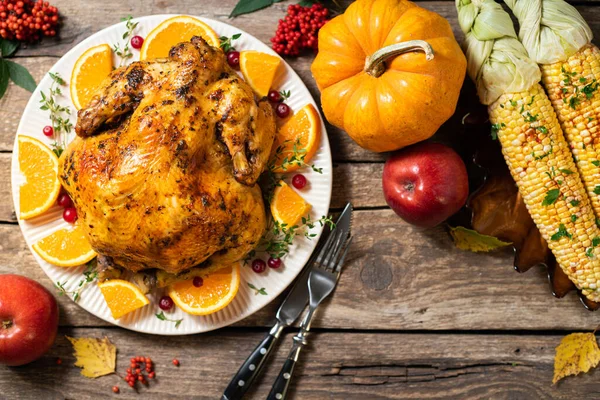 Sonbahar festivali Şükran Günü kompozisyonu. Ahşap masada Şükran Günü yemeği için turunçgil ve baharatlı fırında tavuk ya da hindi. Şükran Günü için masa ayarları