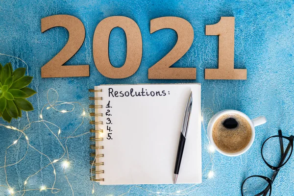 机の上に2021年の新年の決議 2021年の目標は ノートブック コーヒーカップ 眼鏡を青の背景に アイデアの概念 スペースのコピー — ストック写真