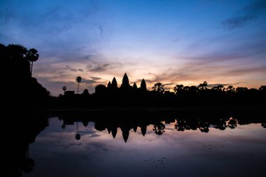Siem Reap, Kamboçya 'daki Angkor Wat' ın silüetinde yansıması.