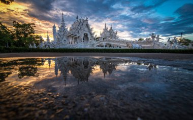 The scenery of reflection of Wat Rong Khun or White temple on sunset time in Chiang Rai, Thailand. clipart