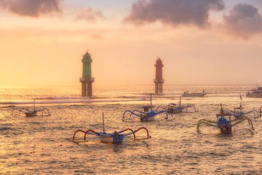 Endonezya, Bali 'de bolca örümcek teknesinin bulunduğu Sanur limanındaki altın gündoğumu manzarası.