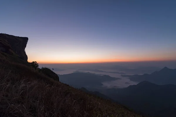 Chiang Rai, Tayland 'da güneş doğmadan önce alacakaranlık gökyüzü ve sis denizi ile Phu Chi Fah manzarası.