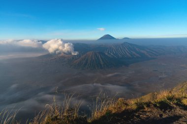 Bromo, Batok ve Semeru yanardağlarının Penanjakkan 'ın Java, Endonezya' daki manzarasından sabah sisli güzel manzarası.