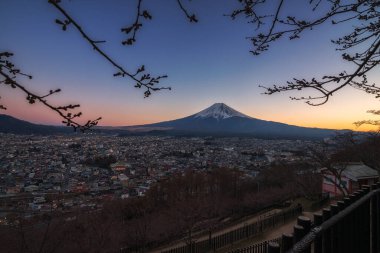 Gün batımında Fuji Dağı 'nın alacakaranlık manzarası Chureito, Japonya' da çiçek açmadan önce kiraz dalları ile.