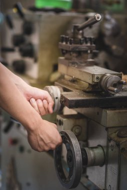 Atölyedeki retro Torna makinesini ayarlayan denetçinin eli.