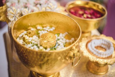 A set of the golden water bowl for holy water in the Thai wedding ceremony and the flower trays decoration. clipart