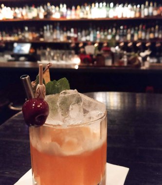 Arka planda bulanık bir çubuk olan bir masada kokteyl..