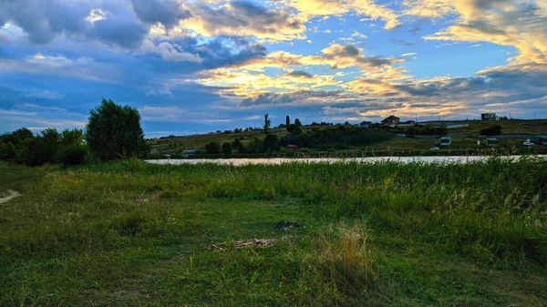 夜の村 雲と日没 湖は輝いている — ストック写真