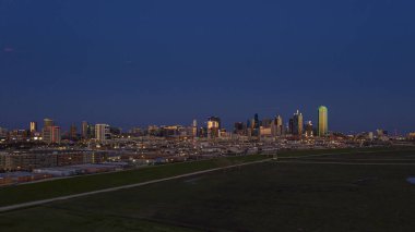 Günbatımında Dallas silueti ve Trammel Crow Parkı 'nın panoramik hava aracı resmi