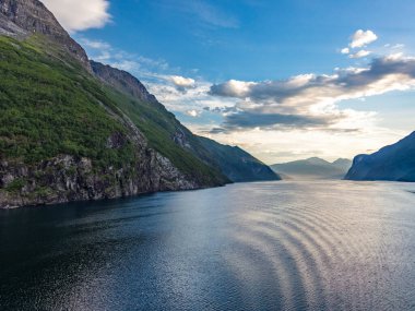 Güneş doğarken Norveç 'teki Geiranger fiyordundan geçerken yolcu gemisinden gelen izlenim