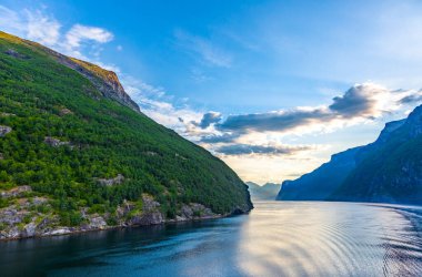 Güneş doğarken Norveç 'teki Geiranger fiyordundan geçerken yolcu gemisinden gelen izlenim