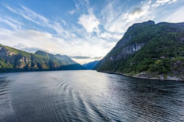 Güneş doğarken Norveç 'teki Geiranger fiyordundan geçerken yolcu gemisinden gelen izlenim